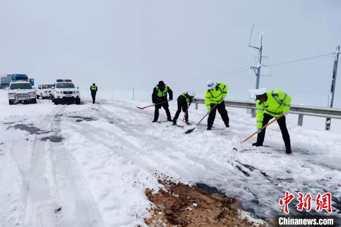 西藏安多交警在海拔5000多米的唐古拉山路段除雪。　安多县公安局 供图